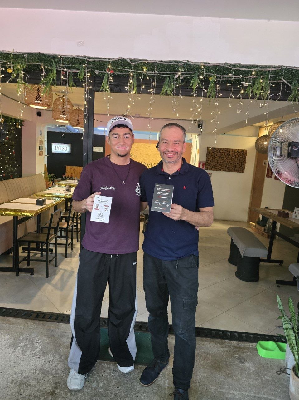 Gerardo Moreno, dueño de Sushi Service, con el QR de Cada1 en su local